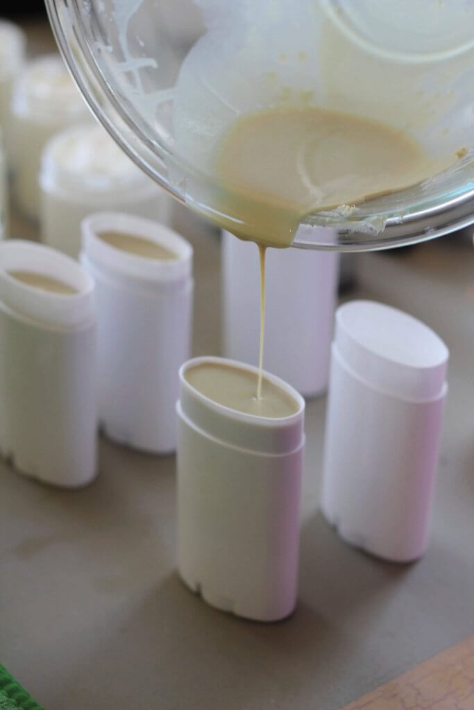 Pouring homemade DIY deodorant into deodorant tubes