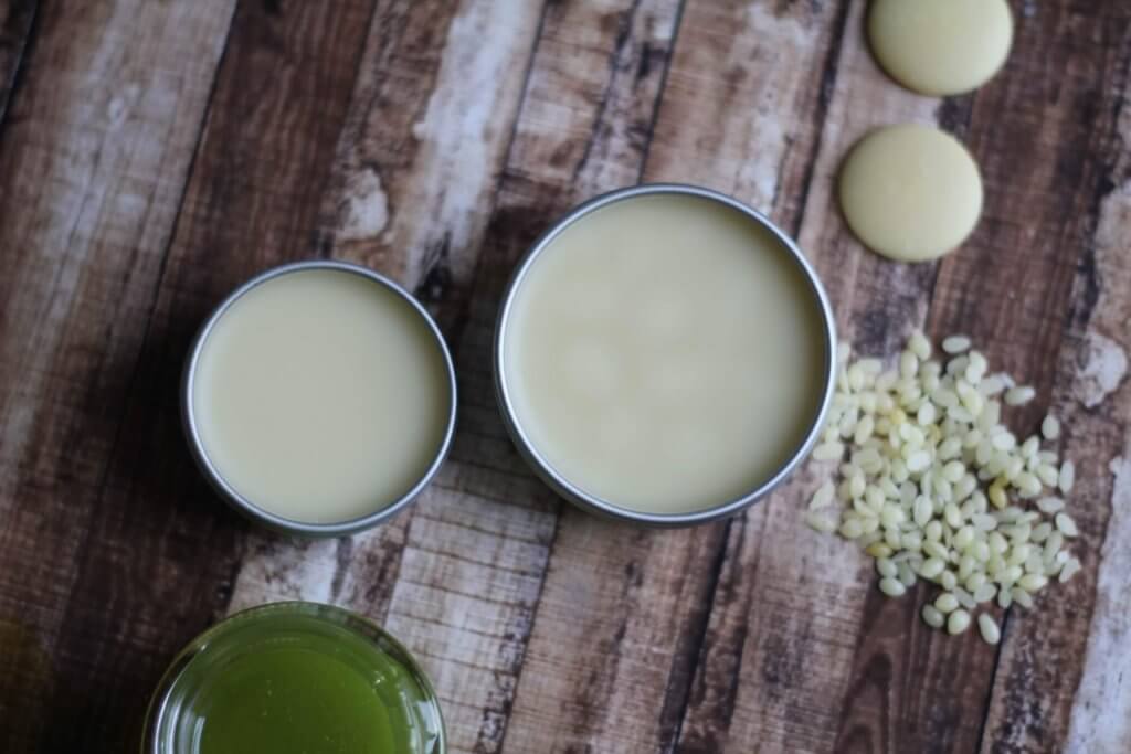 Foot and Heel Salve in containers with raw ingredients surrounding it.