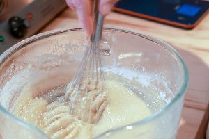 Jess actively whisking powders into a liquid DIY skincare creation.