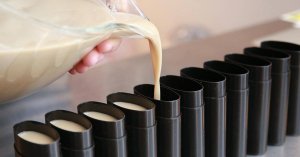 Jess pouring natural deodorant without baking soda into black tubes.