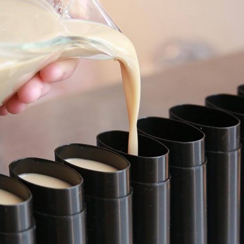 Jess pouring natural deodorant without baking soda into black tubes.