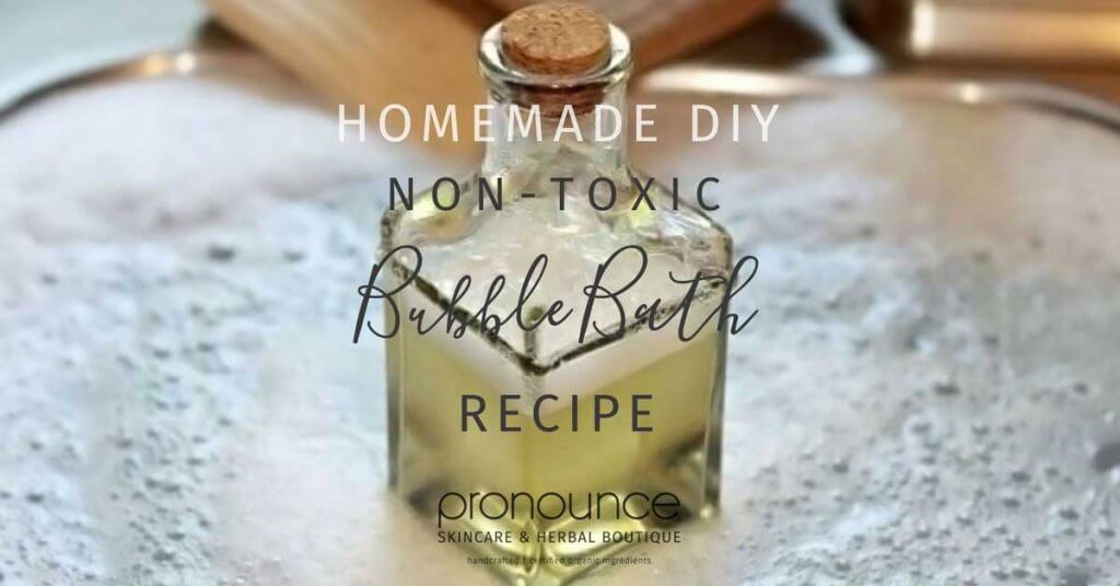 Glass bottle of DIY. non-toxic bubble bath surrounded by bubbles.